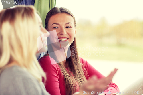 Image of happy young women talking in travel bus or train