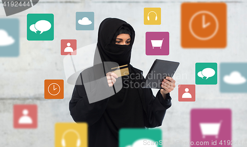 Image of woman in hijab with tablet pc and credit card