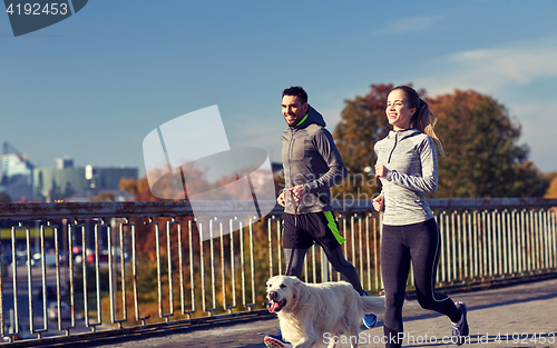 Image of happy couple with dog running outdoors