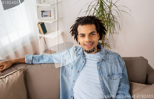 Image of happy smiling afro american man on sofa at home