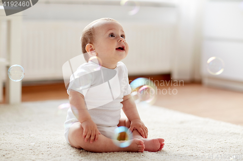 Image of happy baby with soap bubbles at home