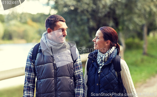 Image of happy family walking with backpacks in woods