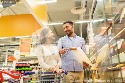 Image of happy couple with shopping cart at grocery store