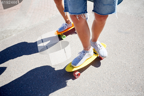 Image of teenage couple riding skateboards on city road