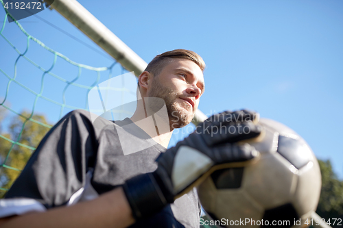 Image of goalkeeper with ball at football goal on field