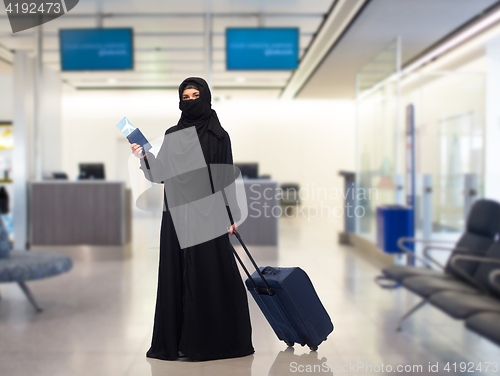 Image of muslim woman with ticket, passport and travel bag