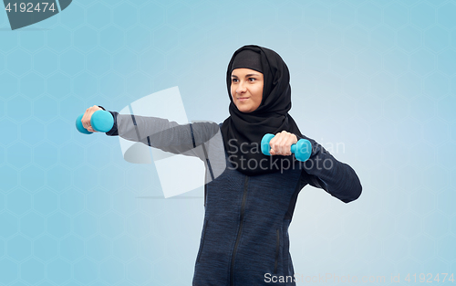 Image of muslim woman in hijab with dumbbells doing fitness