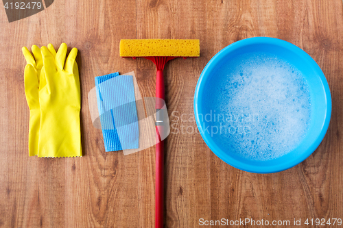 Image of basin with cleaning stuff on wooden background