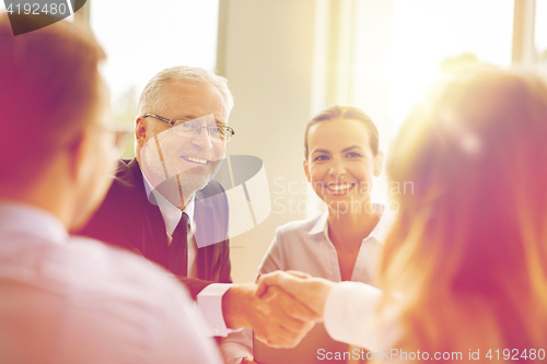 Image of senior businessman making handshake at office