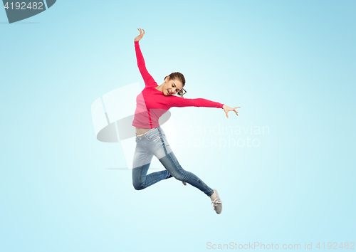 Image of happy young woman jumping in air or dancing