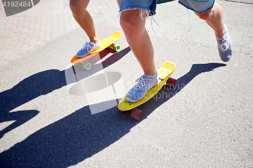 Image of teenage couple riding skateboards on city road