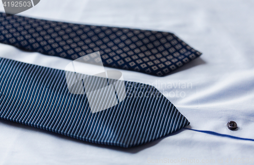 Image of close up of shirt and blue patterned ties