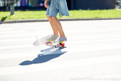 Image of teenage boy on skateboard crossing city crosswalk