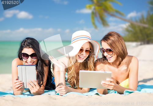 Image of happy young women with tablet pc on summer beach