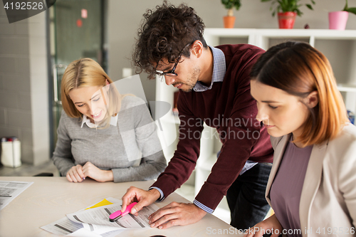 Image of happy business team with papers in office