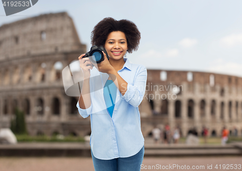 Image of happy afro american woman with digital camera