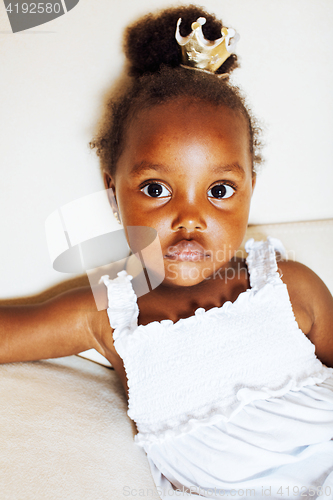 Image of little pretty african american girl sitting in white chair weari