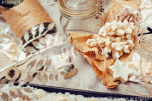 Image of a lot of sea theme in mess like shells, candles, perfume, girl stuff on linen, pretty textured post card view vintage