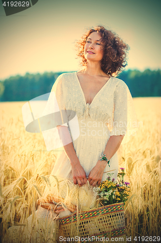 Image of smiling beautiful woman in white summer dress in a field