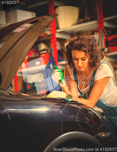 Image of woman car mechanic in a garage