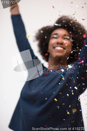 Image of African American woman blowing confetti in the air