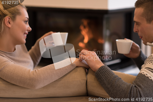 Image of Young couple  in front of fireplace