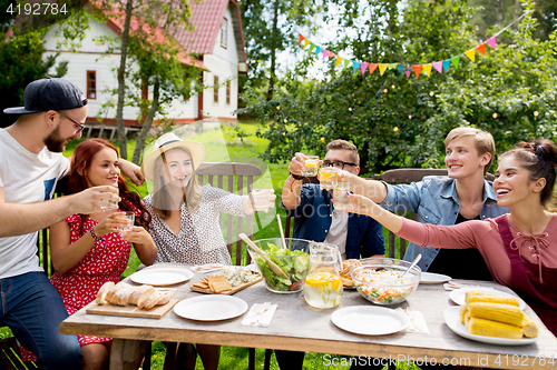 Image of happy friends having party at summer garden