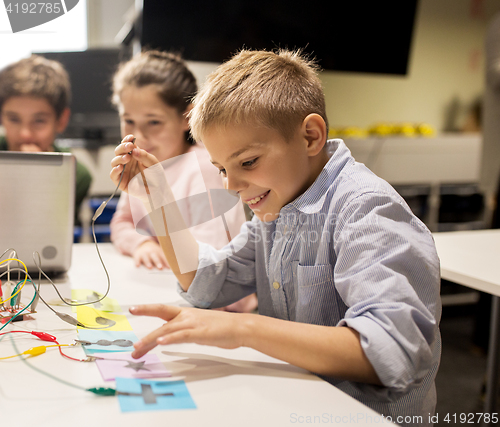 Image of kids, laptop and invention kit at robotics school