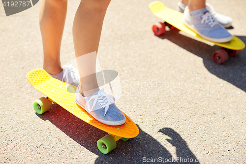 Image of close up of female feet riding short skateboard