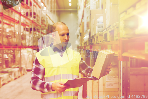 Image of man with clipboard in safety vest at warehouse