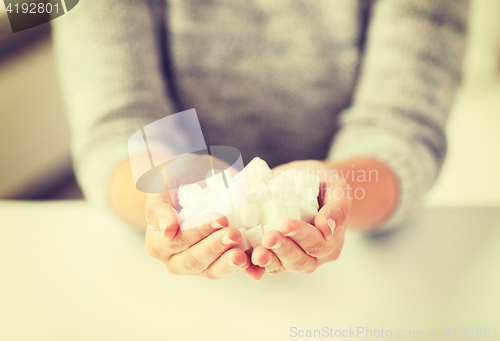 Image of close up of white lump sugar in woman hands