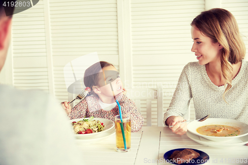 Image of happy family having dinner at restaurant or cafe