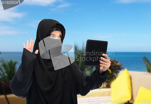 Image of muslim woman in hijab with tablet pc having chat