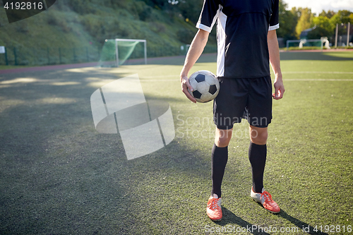 Image of soccer player with ball on football field