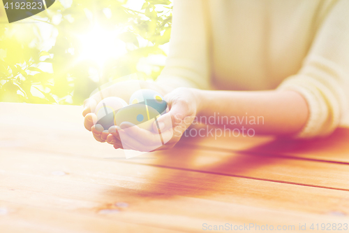 Image of close up of woman hands with colored easter eggs