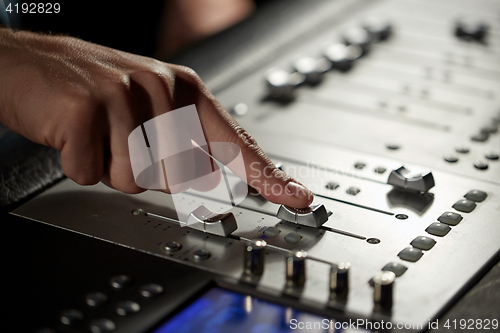 Image of hand with mixing console in music recording studio