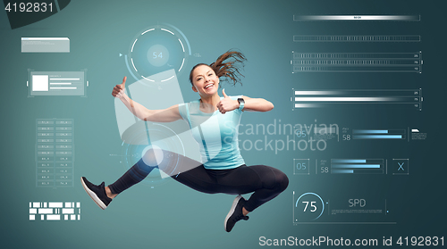 Image of happy sporty woman jumping and showing thumbs up 