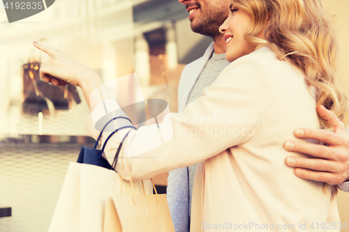 Image of couple with shopping bags looking at shop window