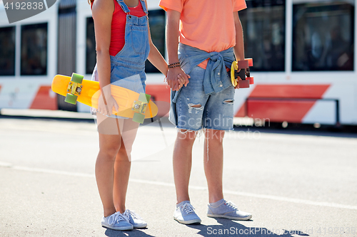 Image of close up of young couple with skateboards in city