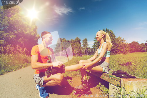 Image of happy couple with rollerblades outdoors