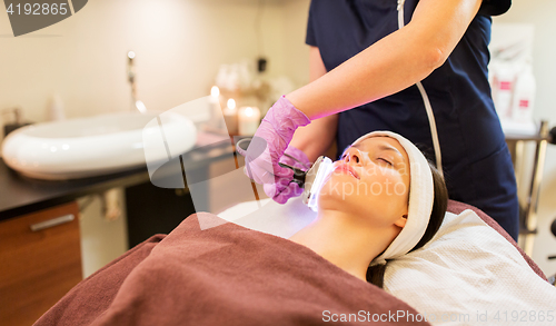 Image of young woman having face microdermabrasion at spa