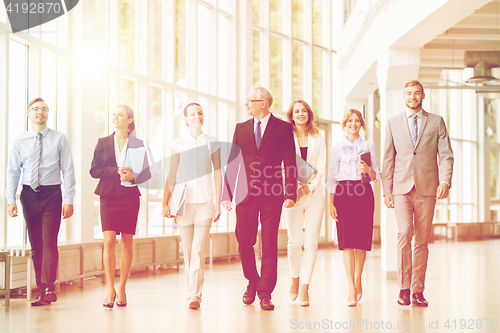 Image of business people walking along office building