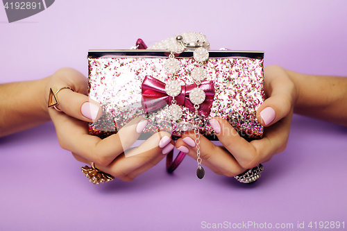 Image of little girl stuff for princess, woman hands holding small cute handbag with jewelry and manicure, luxury lifestyle concept