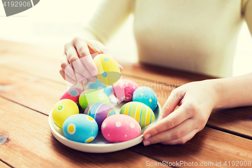 Image of close up of woman hands with colored easter eggs