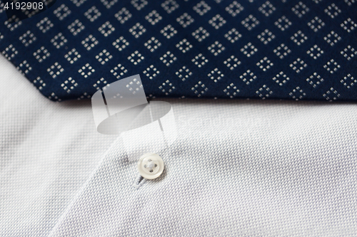 Image of close up of shirt and blue patterned tie