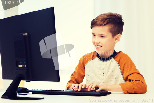 Image of smiling boy with computer at home