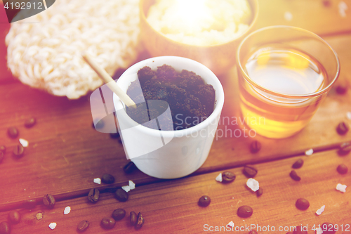 Image of close up of coffee scrub in cup and honey on wood