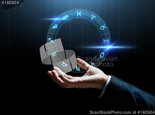 Image of close up of businessman hand with signs of zodiac