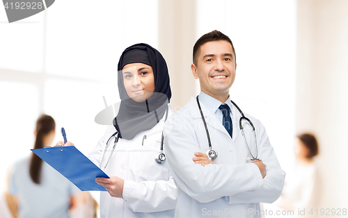 Image of happy doctors with clipboard and stethoscopes