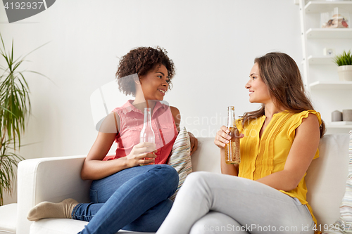 Image of happy women with beer talking at home